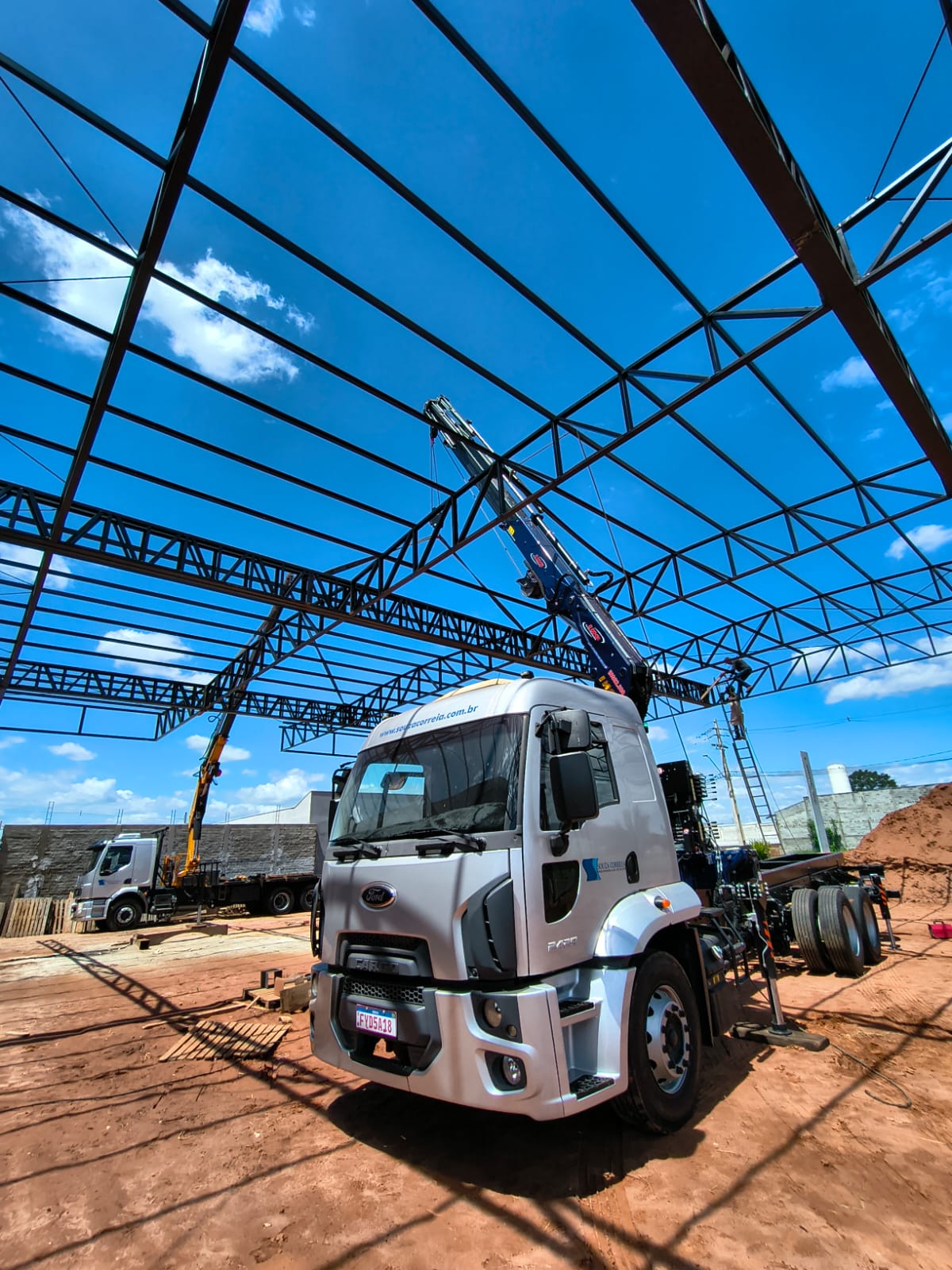 Caminhão guindaste instalando estrutura metálica