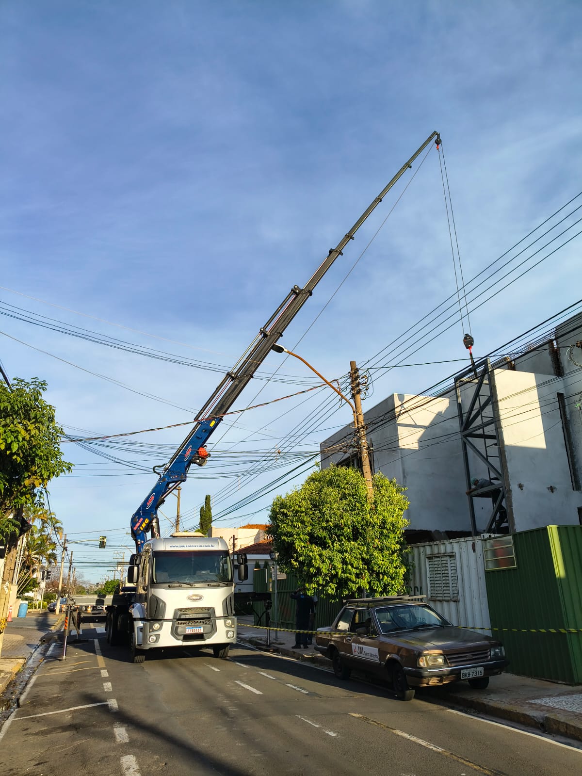 Guindaste hidráulico em operação de içamento urbano