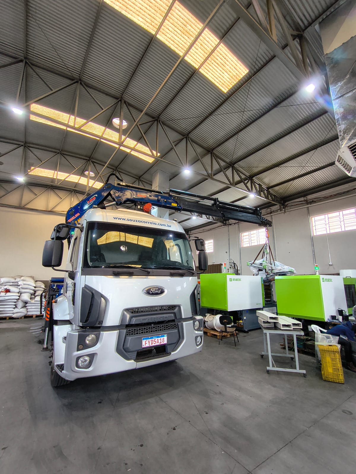 Guindaste movimentando equipamento em ambiente industrial